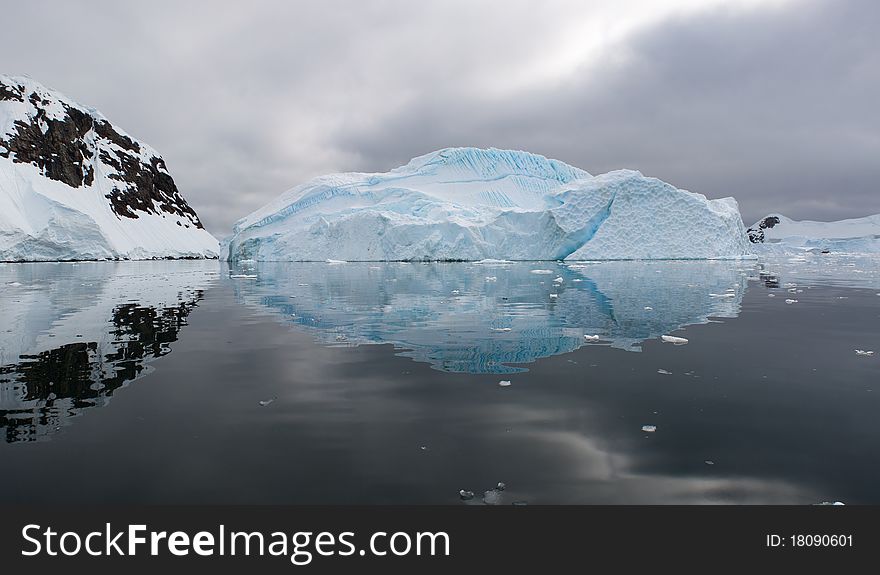 An iceberg scene is reflected in the Antarctic waters. An iceberg scene is reflected in the Antarctic waters