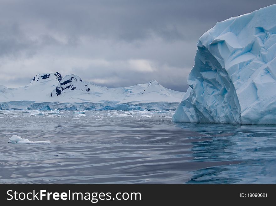 An iceberg is blue in the Antarctic waters. An iceberg is blue in the Antarctic waters