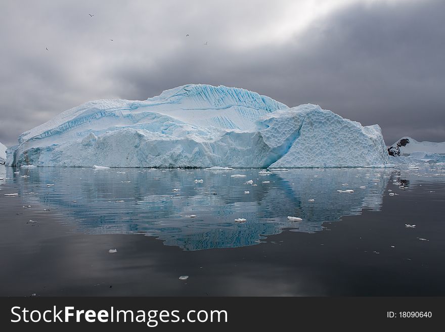 An iceberg scene is reflected in the Antarctic waters. An iceberg scene is reflected in the Antarctic waters