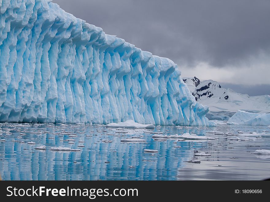 An iceberg is blue in the Antarctic waters. An iceberg is blue in the Antarctic waters