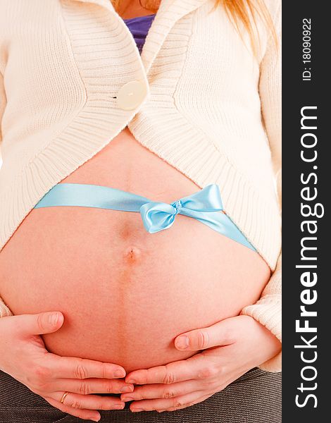 Close up of belly of pregnant woman with blue ribbon. Close up of belly of pregnant woman with blue ribbon