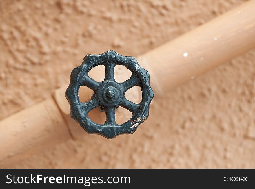 Value and pipe isolated against a light wall background. Value and pipe isolated against a light wall background