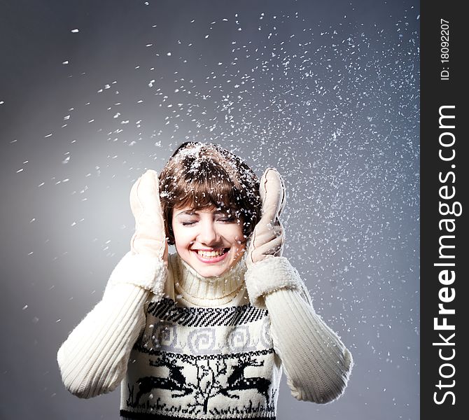 Young beautiful girl rejoices to snow, On a dark blue background