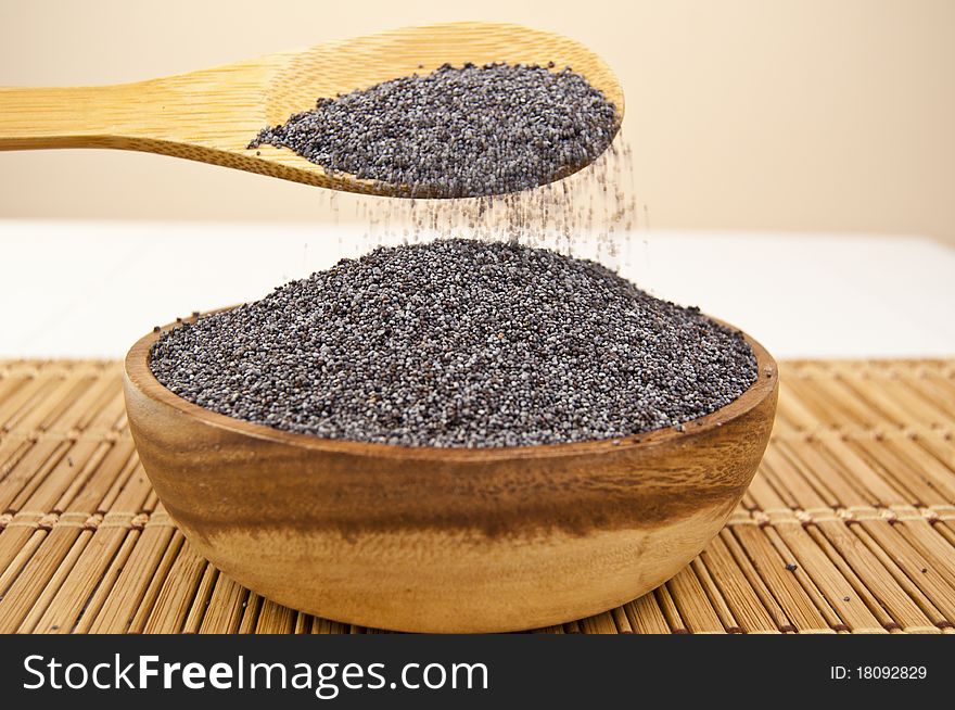 Poppy seeds in a wooden bowl on a table