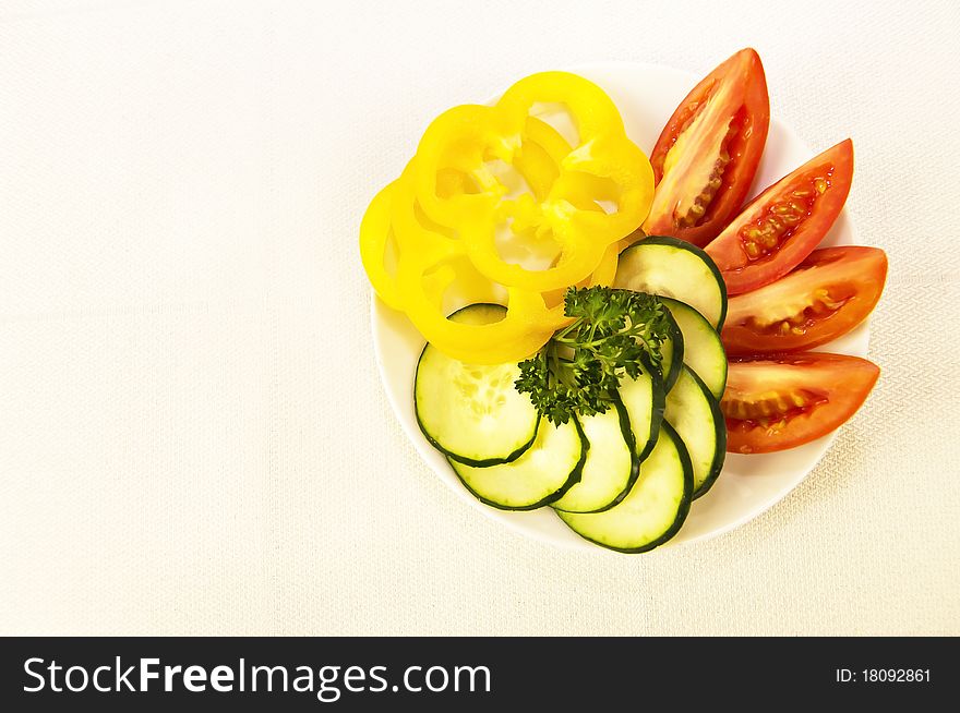 Colored raw vegetables for salad in plate on a table