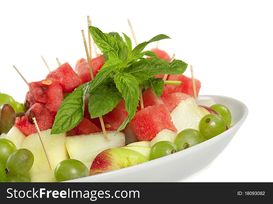 Slices of delicious and healthy fruits with mint isolated on white. Slices of delicious and healthy fruits with mint isolated on white