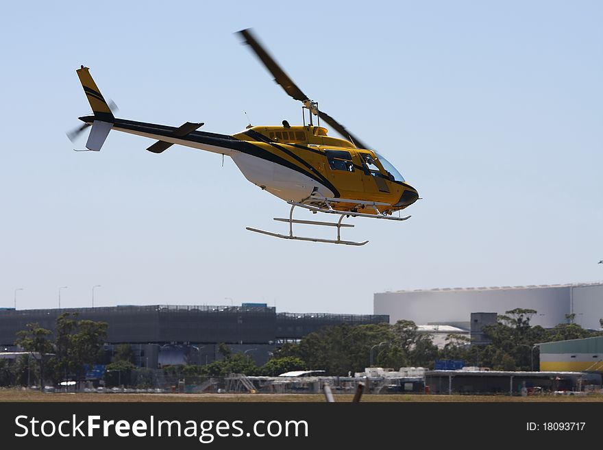 Yellow Helicopter In A Low Fly Over