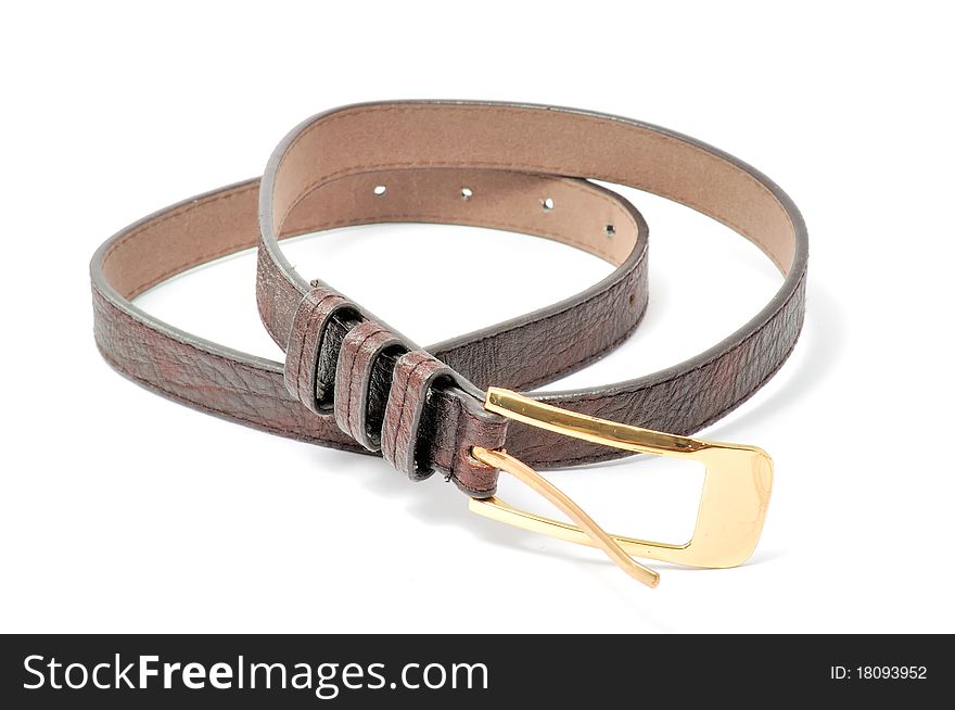 A brown leather belt with a golden buckle isolated on a white background. A brown leather belt with a golden buckle isolated on a white background