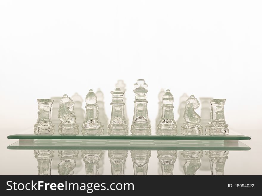 Beautiful glass chess on a white background. Photo taken in the studio on a glass countertop.