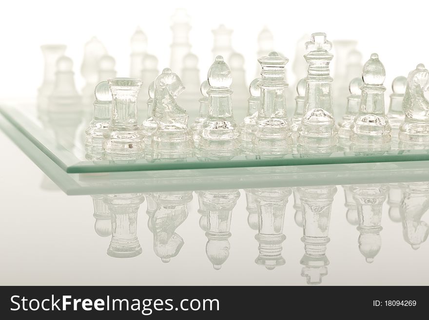 Beautiful glass chess on a white background. Photo taken in the studio on a glass countertop.