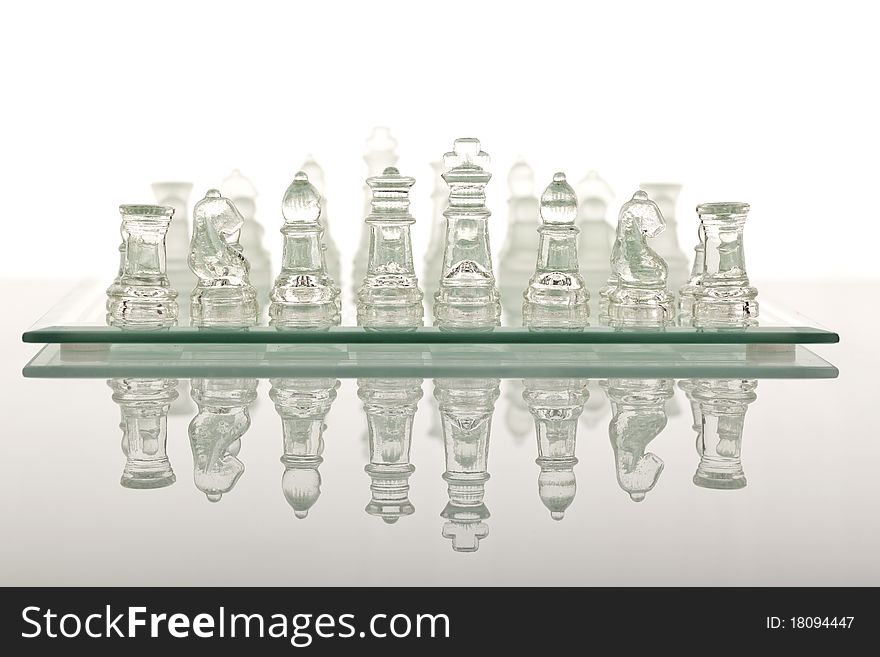 Beautiful glass chess on a white background. Photo taken in the studio on a glass countertop.