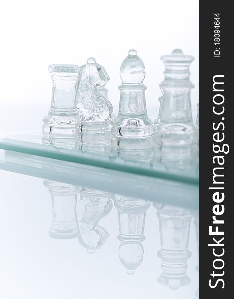 Beautiful glass chess on a white background. Photo taken in the studio on a glass countertop. Beautiful glass chess on a white background. Photo taken in the studio on a glass countertop.