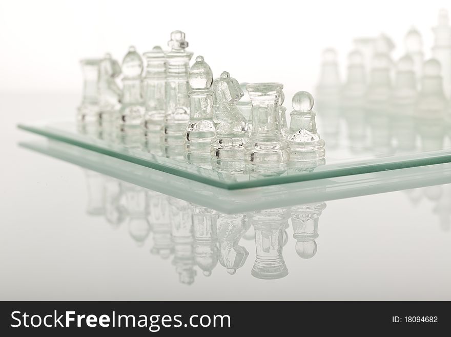 Beautiful glass chess on a white background. Photo taken in the studio on a glass countertop.