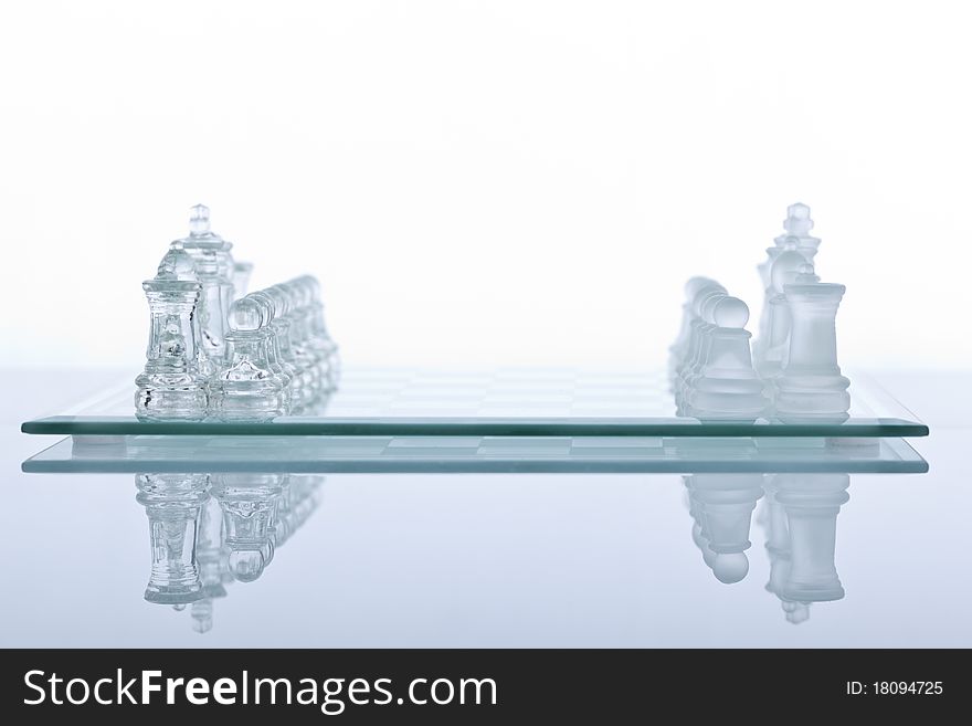 Beautiful glass chess on a white background. Photo taken in the studio on a glass countertop.