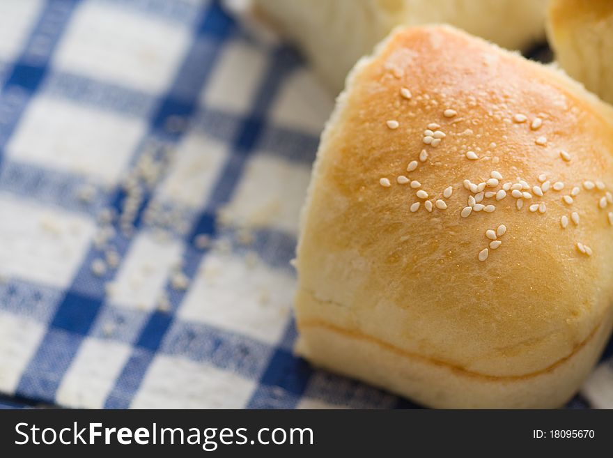 Homemade bread buns with sesam seeds on blue-white napkine