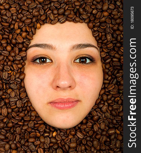 Coffee beans around of face beautiful young woman. Coffee beans around of face beautiful young woman
