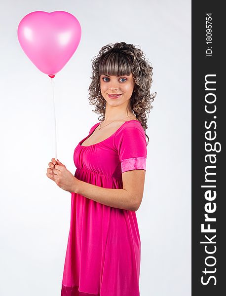 Young beautiful girl holding a balloon heart