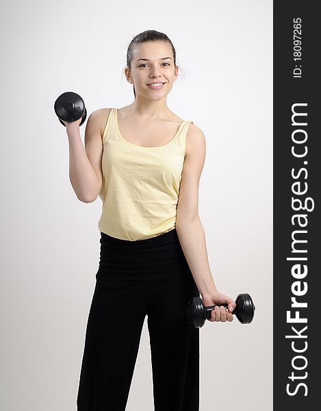 Girl training her body and muscles with dumbbells. Girl training her body and muscles with dumbbells