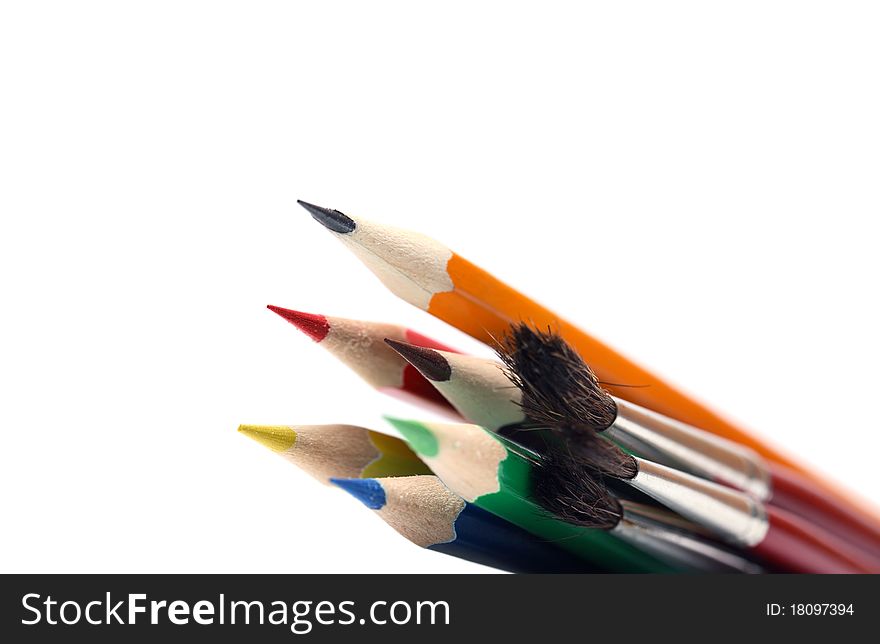 Closeup of paintbrushes and color pencils on white background