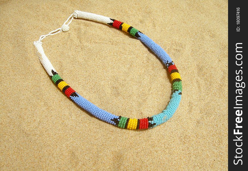 African necklace in the sand.