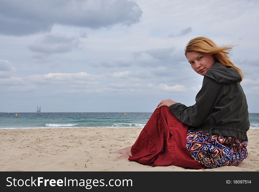 The girl on a beach with white sand and thunderclouds