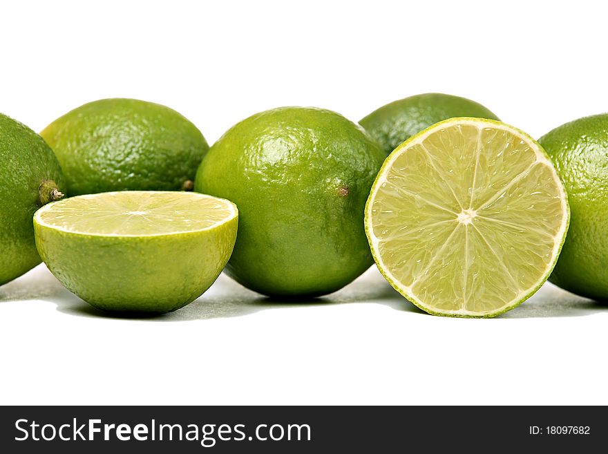 Whole and sliced limes, isolated on white