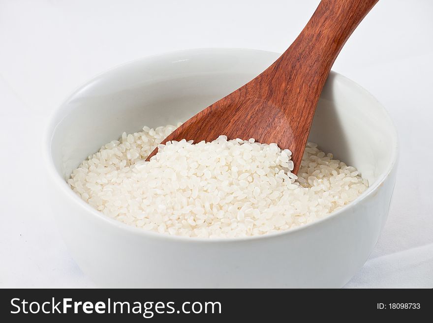 Rice with wood spoon in a bowl. Rice with wood spoon in a bowl