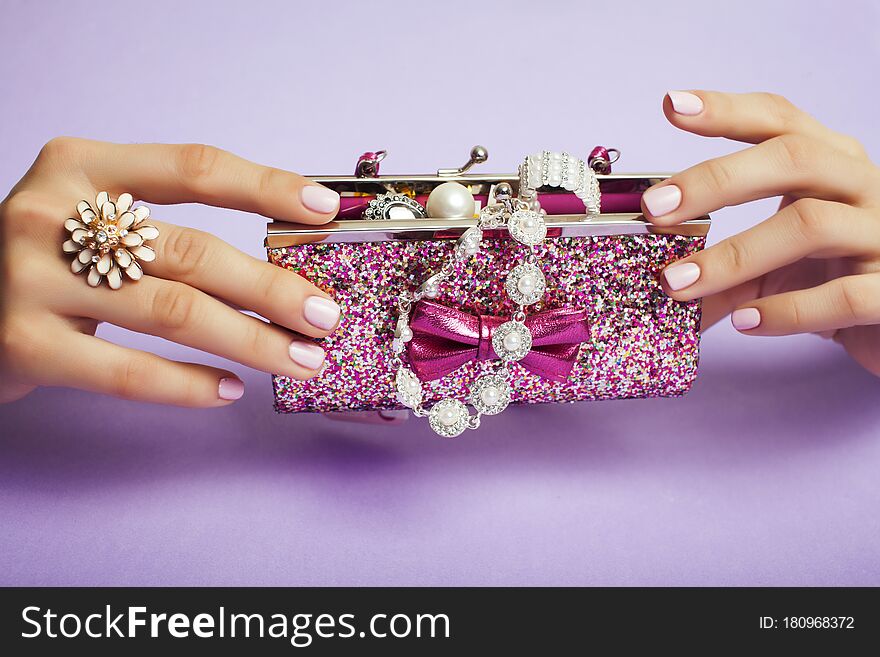 Little girl stuff for princess, woman hands holding small cute handbag with jewelry and manicure, luxury lifestyle concept closeup