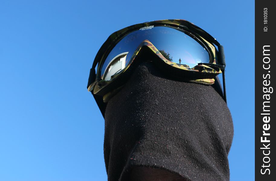 Masked Snowboarder on Blue sky background