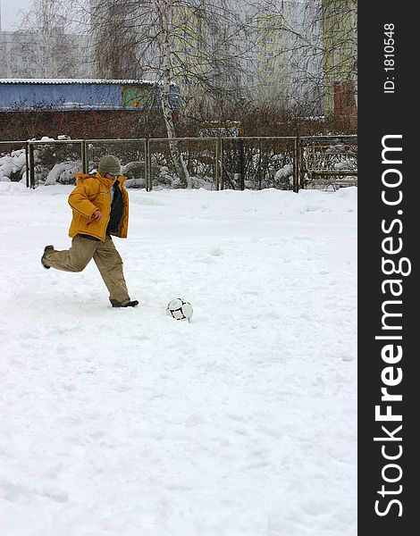 The child playing football. Winter. The child playing football. Winter