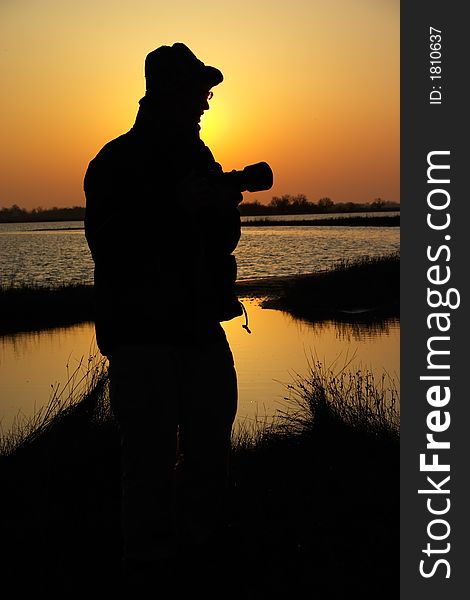 Silhouette of a man with photocamera against a sunrise. Silhouette of a man with photocamera against a sunrise