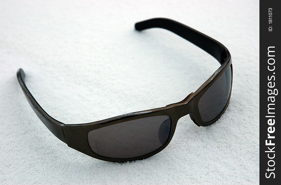 Sunglasses on to snow on a white background