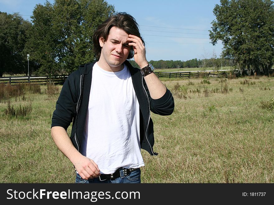 Photo of a young man outside in a field. Photo of a young man outside in a field