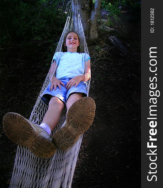 Young girl resting in a mesh hammock. Young girl resting in a mesh hammock