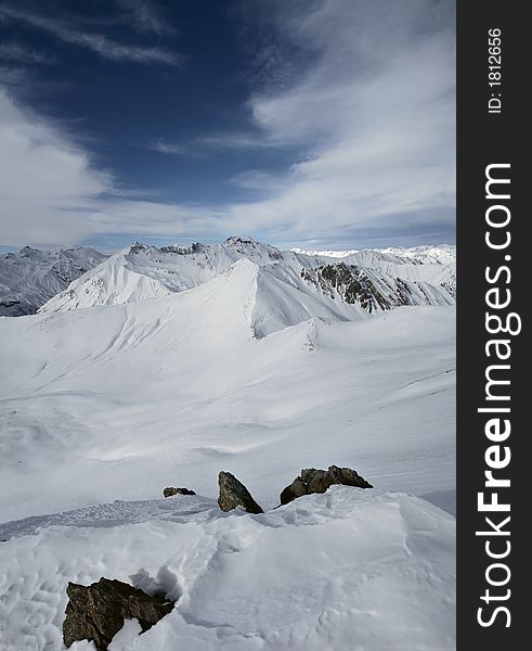 Mountain peaks in Georgia, near Gudauri ski resort.  View is from Sutzelly Mountain. Vertical panorama. Mountain peaks in Georgia, near Gudauri ski resort.  View is from Sutzelly Mountain. Vertical panorama.