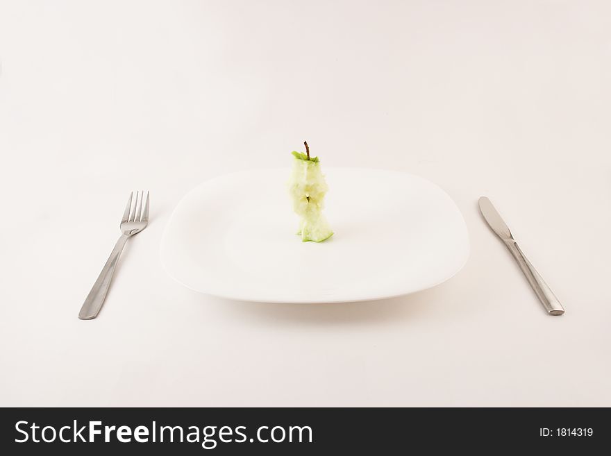 Apple stump on a plate with fork and knife