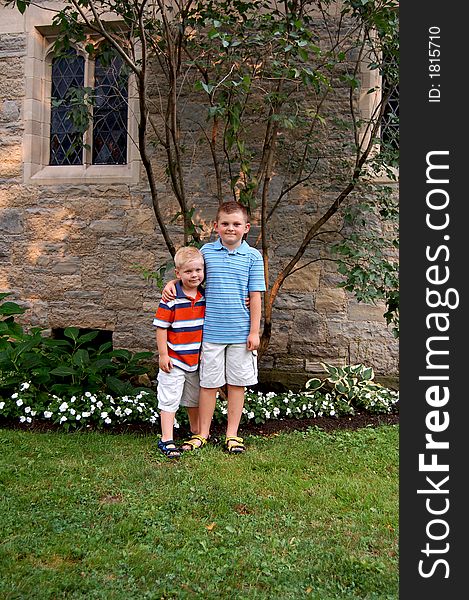 Two brothers standing together in front of a church. Two brothers standing together in front of a church.