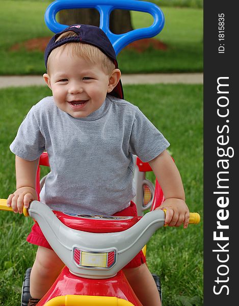 One year old boy riding on a toy and laughing. One year old boy riding on a toy and laughing.