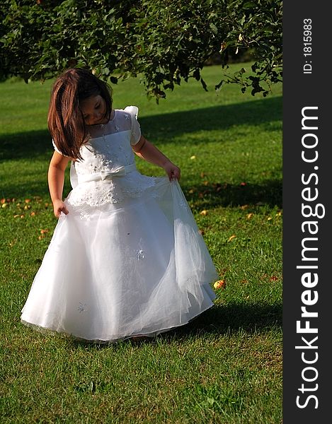 Four year old flower girl in white dress dancing outside. Four year old flower girl in white dress dancing outside.