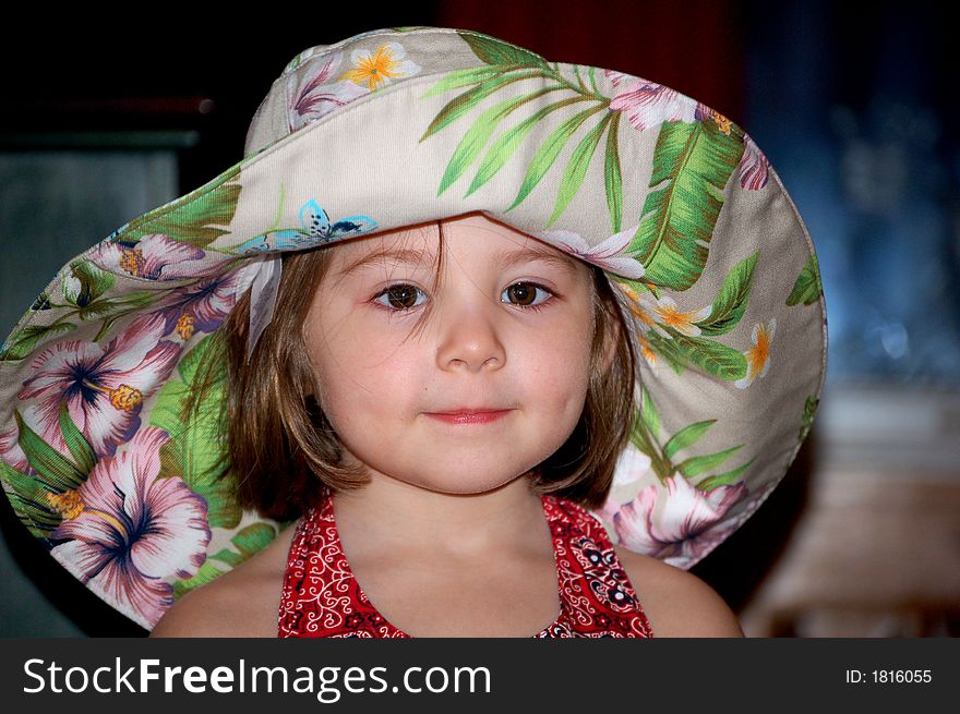 Four year old girl in a large floral sunhat. Four year old girl in a large floral sunhat.