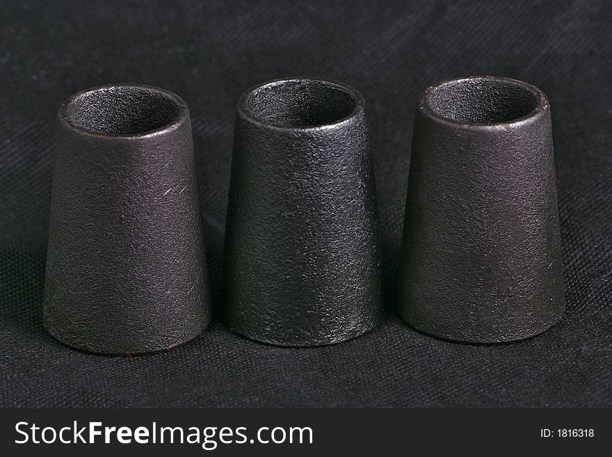 Three candlesticks from metal. macro, black background. Three candlesticks from metal. macro, black background.