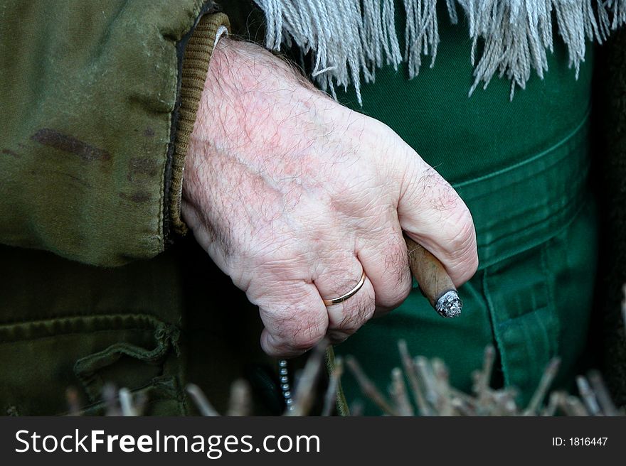 Old-man got cigar between his fingers
