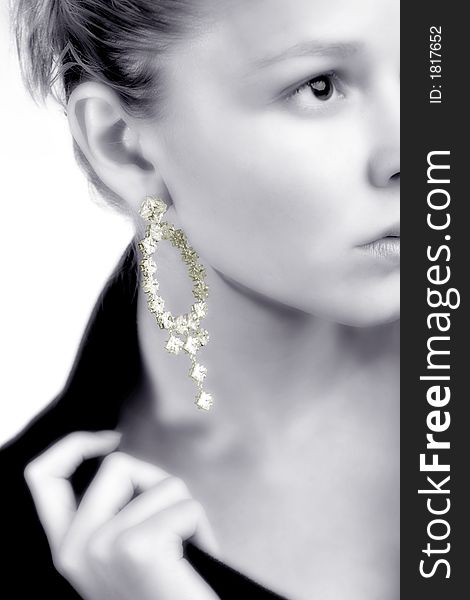 A model portrait in the studio presenting her earring in black and white keeping the earring in colour. A model portrait in the studio presenting her earring in black and white keeping the earring in colour