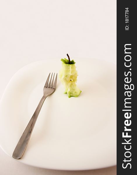 Stump apple with fork set on a white plate