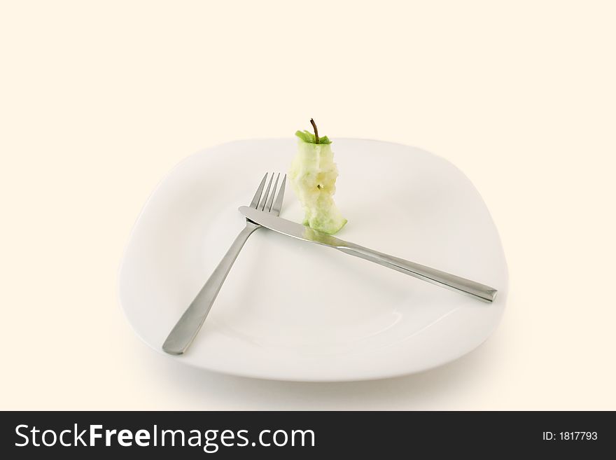 Stump apple on a plate with knife and fork