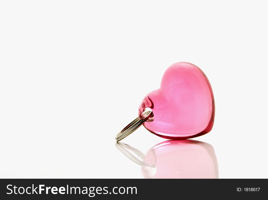 Pink heart shape key-ring over white background