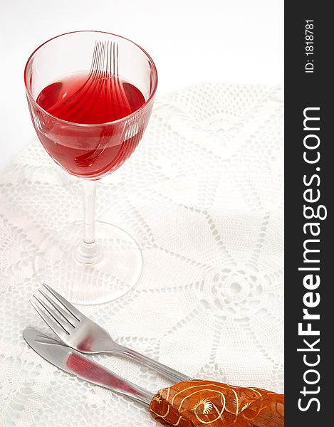 Red glass of wine with fork and knife