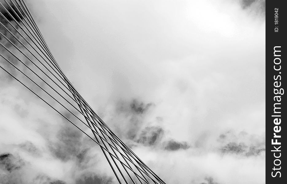 Sky and clouds with infrared filter.
Bridge wires in foreground.Detail of modern bridge.Black and white.