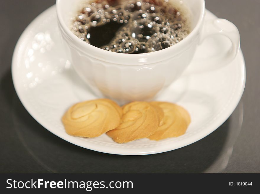 Dark coffee and cookies isolated on black