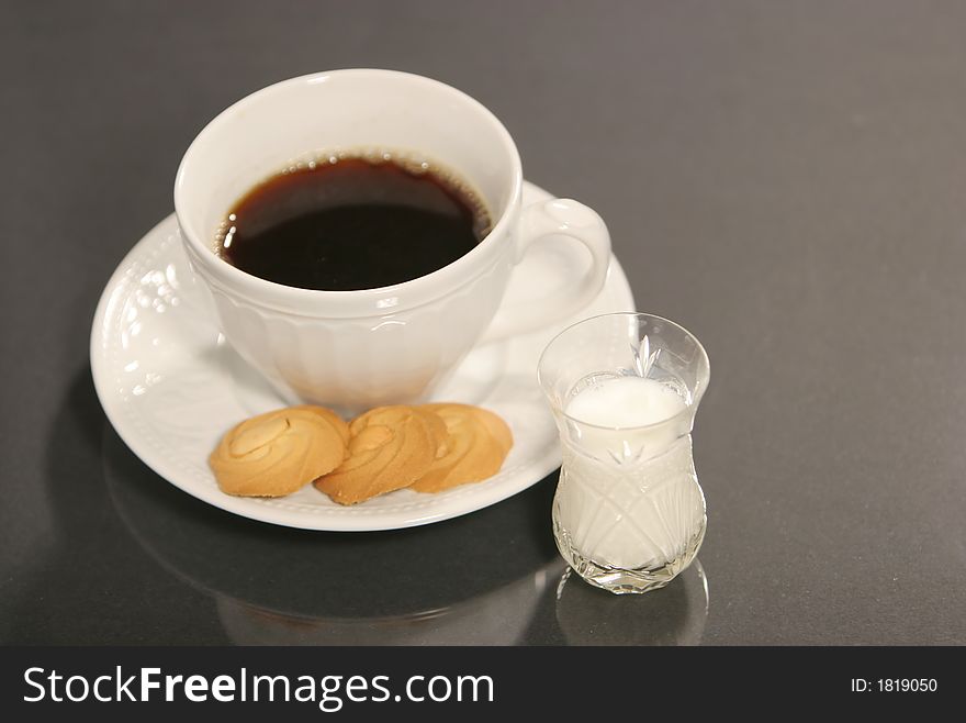 Milk, coffee and cookies isolated on black